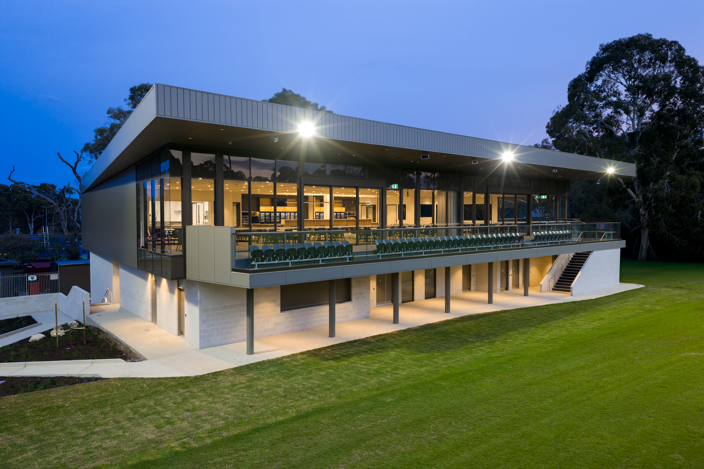New clubrooms building showing interior of building through windows and grassed area in front