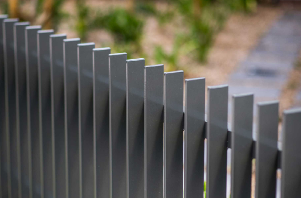 Grey metal fence, with rectangle vertical poles.