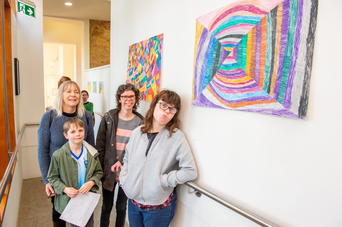 People standing next to a wall with artwork on it