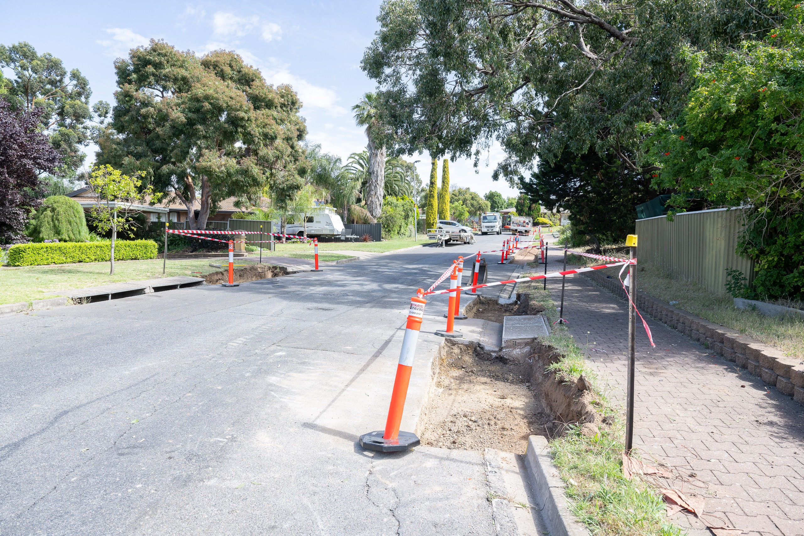 View of street with road works in progress, sections of kerb dug up for new concrete to be installed
