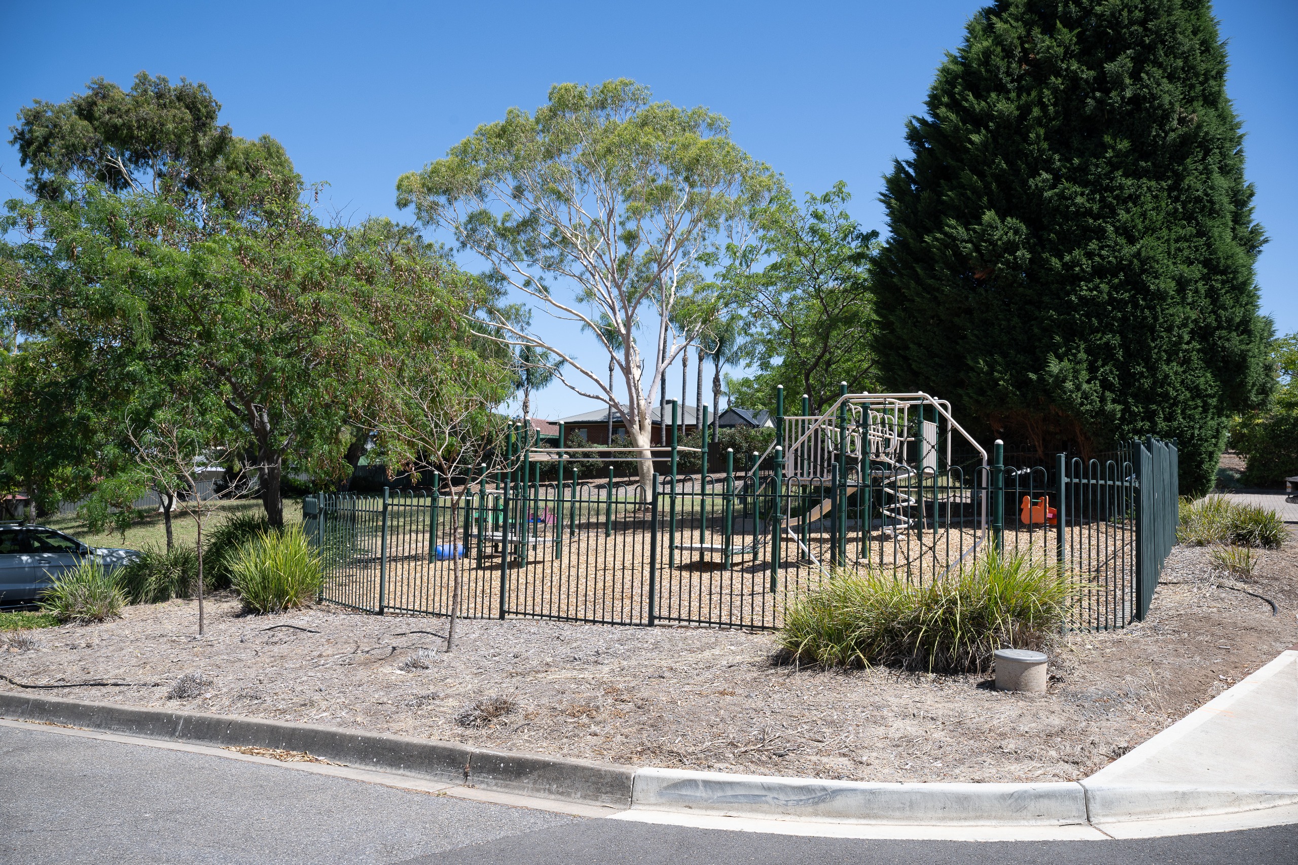 Playspace behind a green metal fence